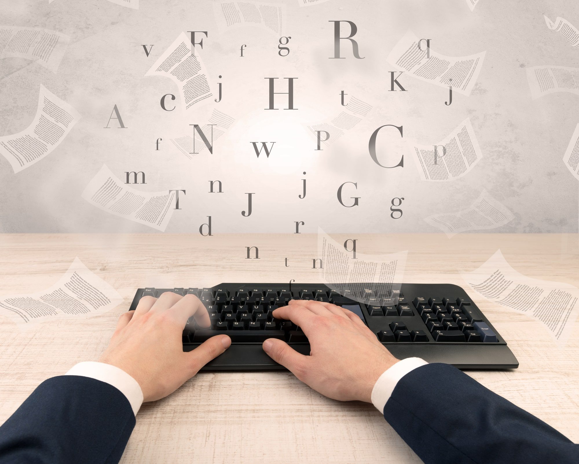 business person's hands on a keyboard while documents and letters fly around, illustrating content scaling and how to scale content creation